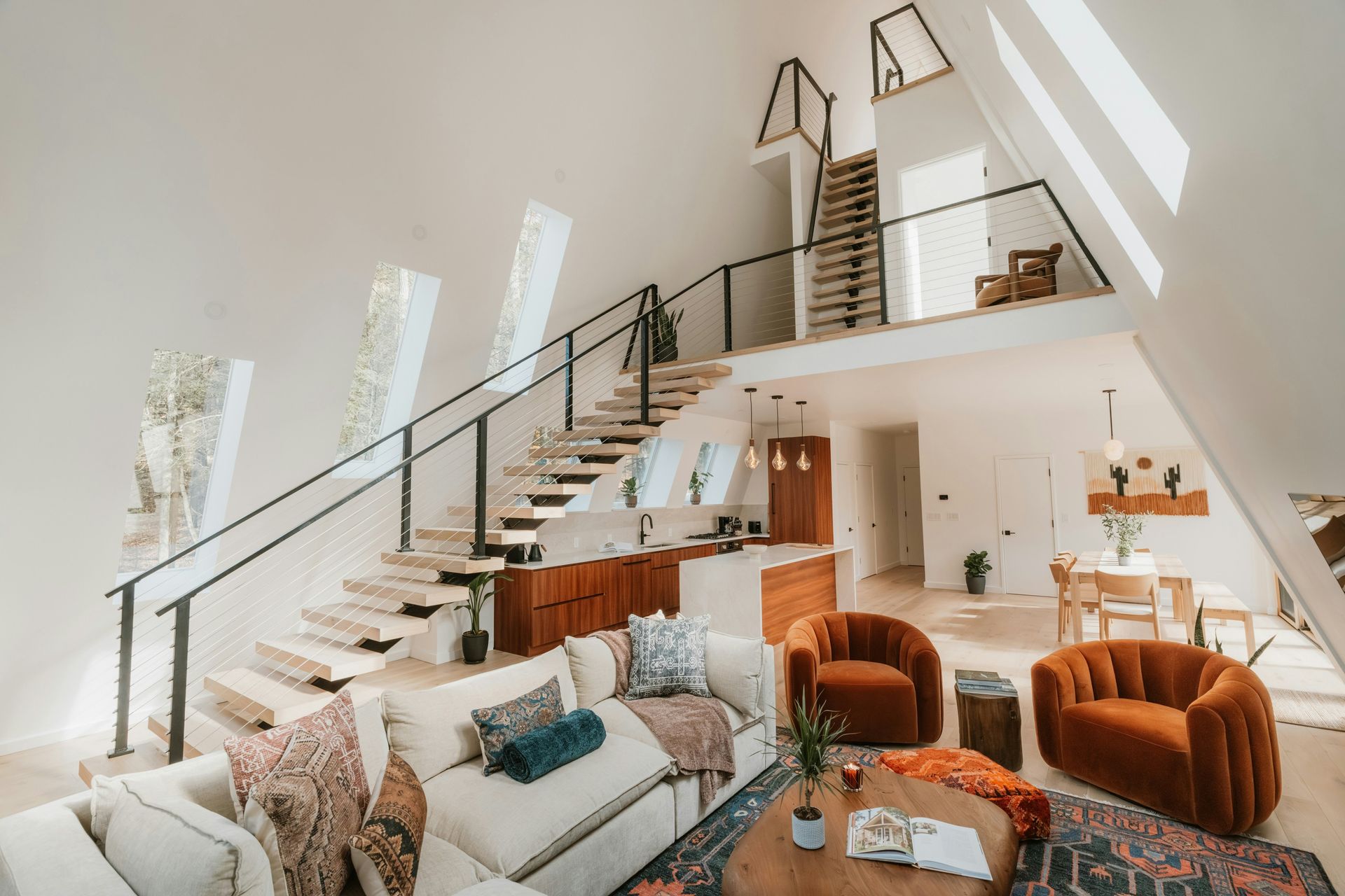 Modern a-frame living room with open loft and kitchen.
